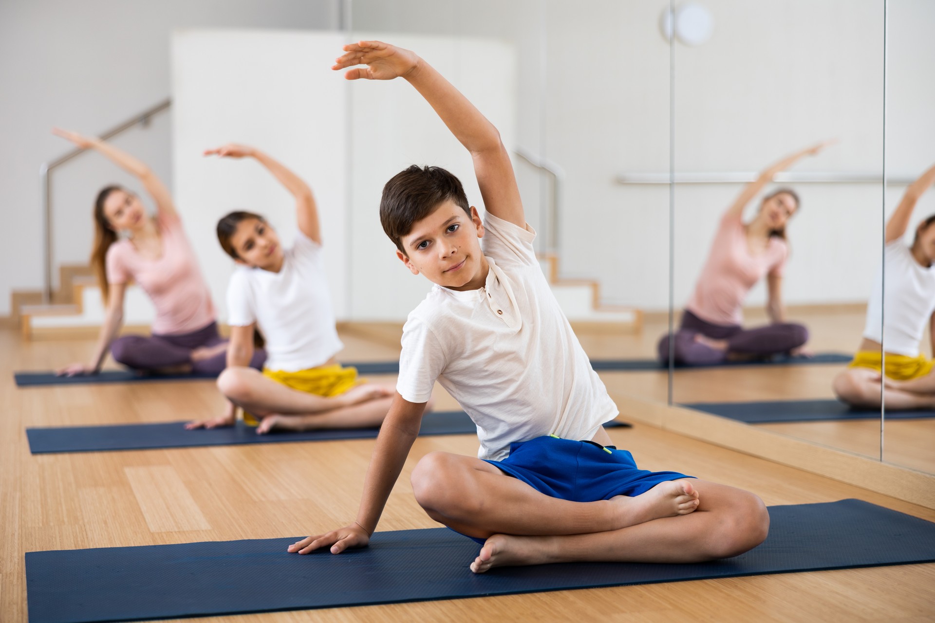 Boy practicing yoga at studio with family